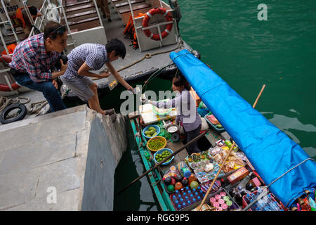 Customers buying products from a boat on Halong Bay, Vietnam, Asia Stock Photo