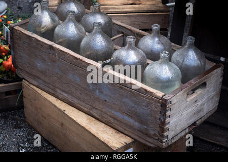 Empty old bottles in a wooden box at the market. Can be used to decorate an apartment Stock Photo