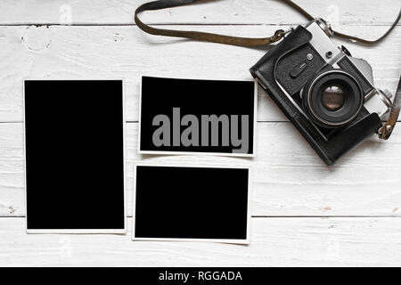 vintage retro camera on wood table background with blank photos to placed your pictures Stock Photo