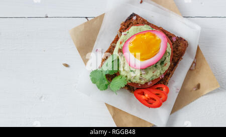 Sandwich with Purple beet pickled eggs, avocado and tomato, copy space. Stock Photo