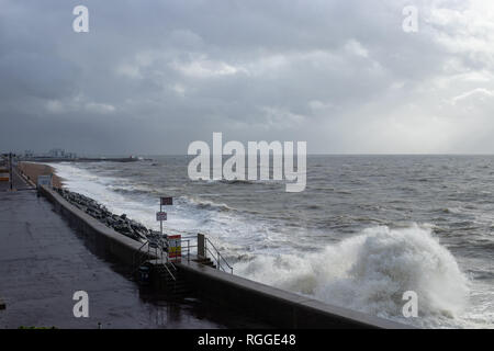 waves breaking against the sea wall defences at Southsea beach on a stormy day Stock Photo