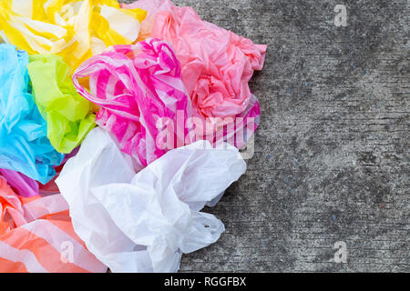Colorful disposable plastic bags on cement floor Stock Photo