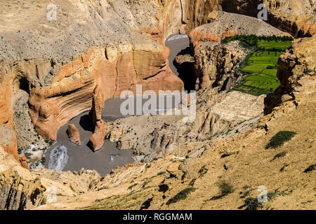 Eroded deep rocky river valley with some green fields in Upper Mustang Stock Photo