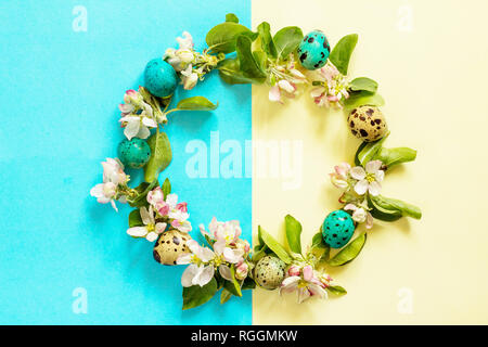 Wreath of spring branches on a blue and yellow background. Minimal easter concept. Top view flat lay background. Stock Photo