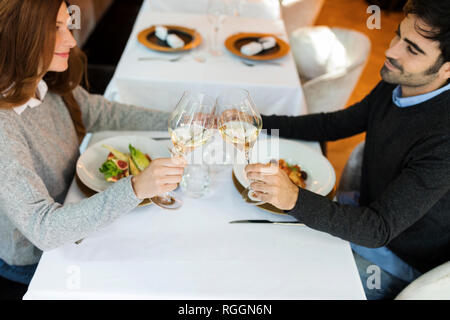 Smiling couple clinking wine glasses in a restaurant Stock Photo