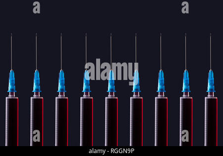 Multiple syringes organized in a pattern over dark background Stock Photo