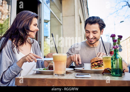 Happy young couple having lunch at outdoors restaurant Stock Photo