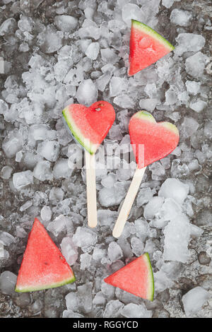 Watermelon heart ice lollies on crashed ice Stock Photo