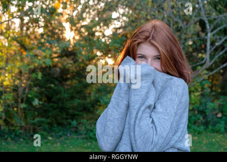 Portrait of teenage girl wearing grey pullover in autumn Stock Photo