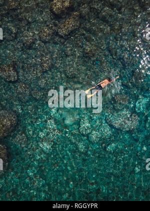 Indonesia, Bali, Man swimming in ocean at Amed beach Stock Photo