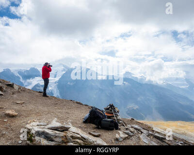 Italy, Trentino, Monte Cevedale, Punta San Matteo, hiker photographing Stock Photo