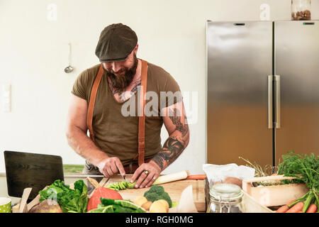 Mature man trying out vegetarian online-recipes Stock Photo