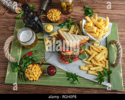 Sandwich beef pulled , barbeque, toast, french fries, sauce, corn on a wooden tray Stock Photo
