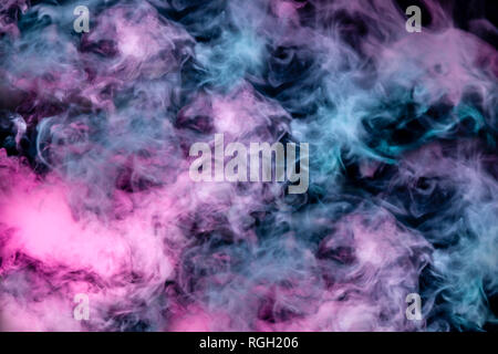 Beautiful pattern of smoke on a black background from the evaporating waves in the neon light of pink blue and purple as sea pebbles in the foam for T Stock Photo