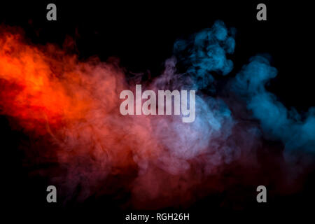 Collision of two streams of smoke with the transition of the colors of blue and red through the pigment molecules on a black background. Stock Photo