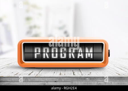 Program message on a retro clock in orange on a wooden table in bright light Stock Photo