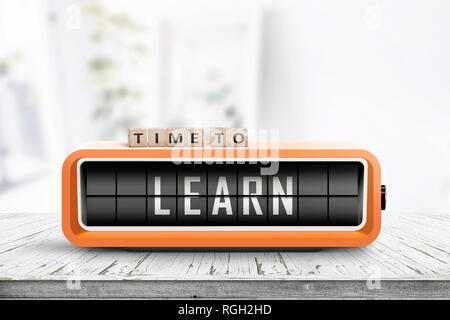 Time to learn message on a retro alarm clock in a bright room on a wooden desk Stock Photo