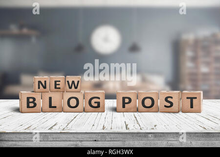 New blog post sign on a wooden desk with a stylish living room on a blurry background Stock Photo