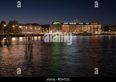 Colourful reflections in Lake Geneva of buildings and their lights on Geneva's Rive Gauche during the blue hour just before nightfall Stock Photo