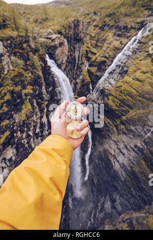 Hand holding compass in Norway Stock Photo