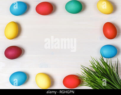 Multi-colored eggs and artificial green grass on a white background. Easter concept. Copy space Stock Photo