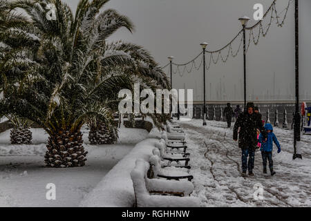 People struggle with the snow and icy conditions while walking along Torquay seafront during the 'Beast from the East' storm in March 2018. Stock Photo