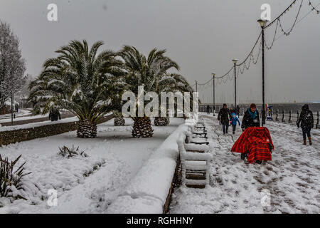 A family struggle with the snow and icy conditions while walking along Torquay seafront during the 'Beast from the East' storm in March 2018. Stock Photo