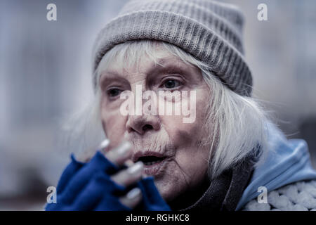 Portrait of a gloomy poor elderly woman Stock Photo