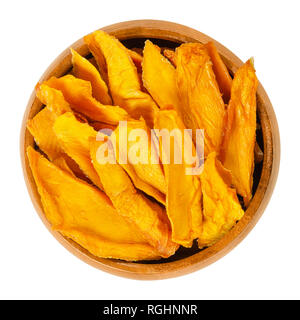 Dried mango strips in wooden bowl. Sliced, dehydrated mangoes. Juicy tropical stone fruit with yellow and orange color. Mangifera. Stock Photo