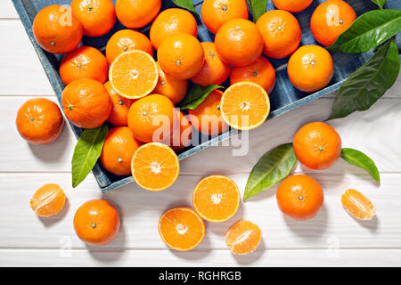 Fresh tangerine fruits with leaves on wooden table. Healthy food concept. Vitamin C Stock Photo