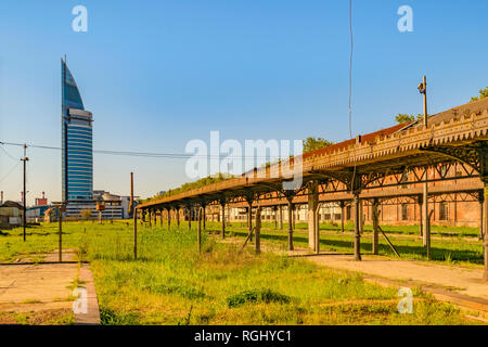 Abandoned old train station with contemporary tower building at background in aguada district, Montevideo, Uruguay Stock Photo