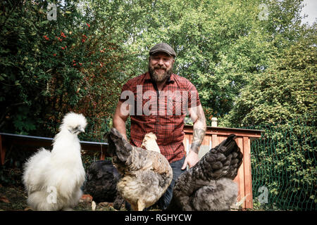 Man in his own garden, free range chickens Stock Photo