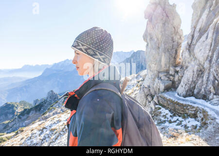 Germany, Garmisch-Partenkirchen, Alpspitze, Osterfelderkopf, female hiker on viewpoint looking at view Stock Photo