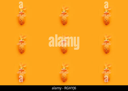 Seamless pattern background of Easter bunny toys on same color backdrop, minimalistic retro style composition Stock Photo