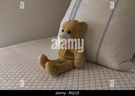 Teddy bear on a bed in bedroom at home Stock Photo