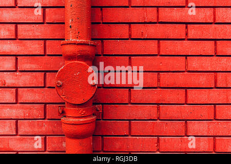 Gutter downpipe and brick wall as urban background Stock Photo