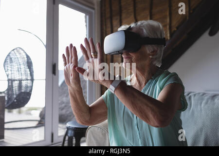 Senior woman using virtual reality headset Stock Photo