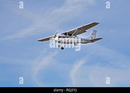 A single-engine, single wing Cessna Skyhawk, the most popular small aircraft among pilot instructors in the world, makes touch and go landings at a sm Stock Photo