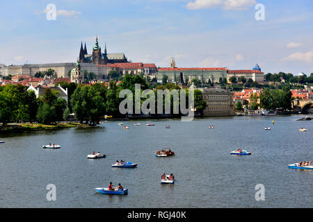 Small hire boats on the river Vltava in old town Prague with the castle behind Stock Photo