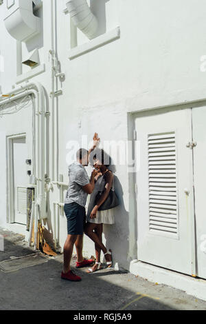 Smiling affectionate young couple standing at building Stock Photo