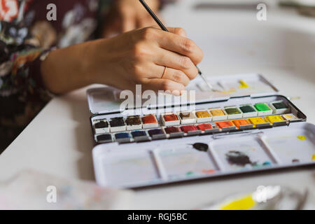 Illustrator painting at work desk in an atelier, close-up Stock Photo