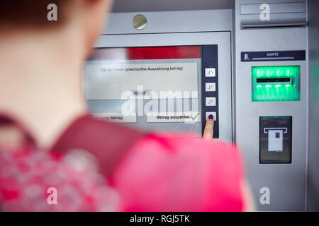 Close-up of woman using cash machine Stock Photo