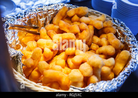 Youtiao (Chinese fried churros, Chinese cruller, Chinese oil stick, Chinese doughnut, fried breadstick), long golden brown deep fried dough strip, eat Stock Photo