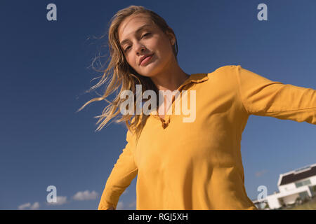Woman standing with arms outstretched on the beach Stock Photo