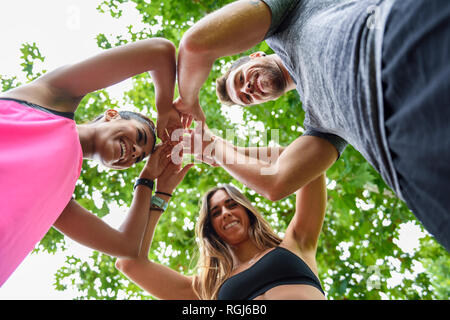 Young sports team stacking hands, celebrating success Stock Photo