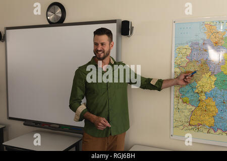 Teacher pointing at a map in classroom Stock Photo