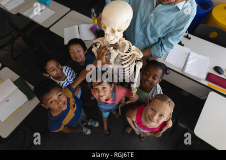 Overhead of schoolkids looking at camera in classroom of elementary school Stock Photo