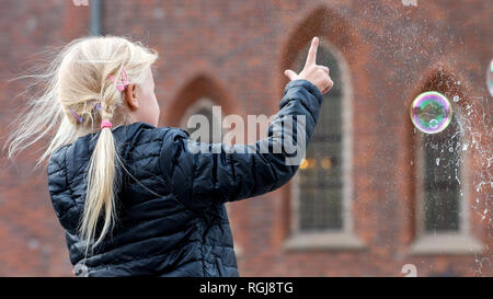 Young Female Busker Making Bubbles For Childern To Play with In The Center of Wrocław, Poland Stock Photo