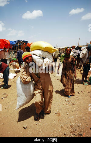 Lalibela, Ethiopia, 13th June 2009: Old man carrying heavy load in the market Stock Photo