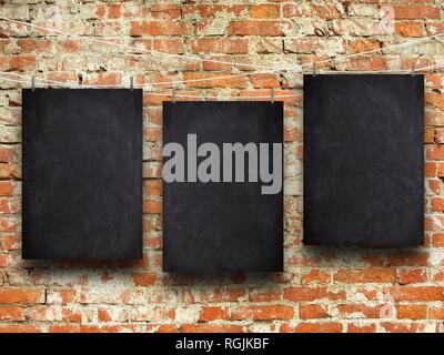 Three blank blackboard frames against orange brick wall background Stock Photo